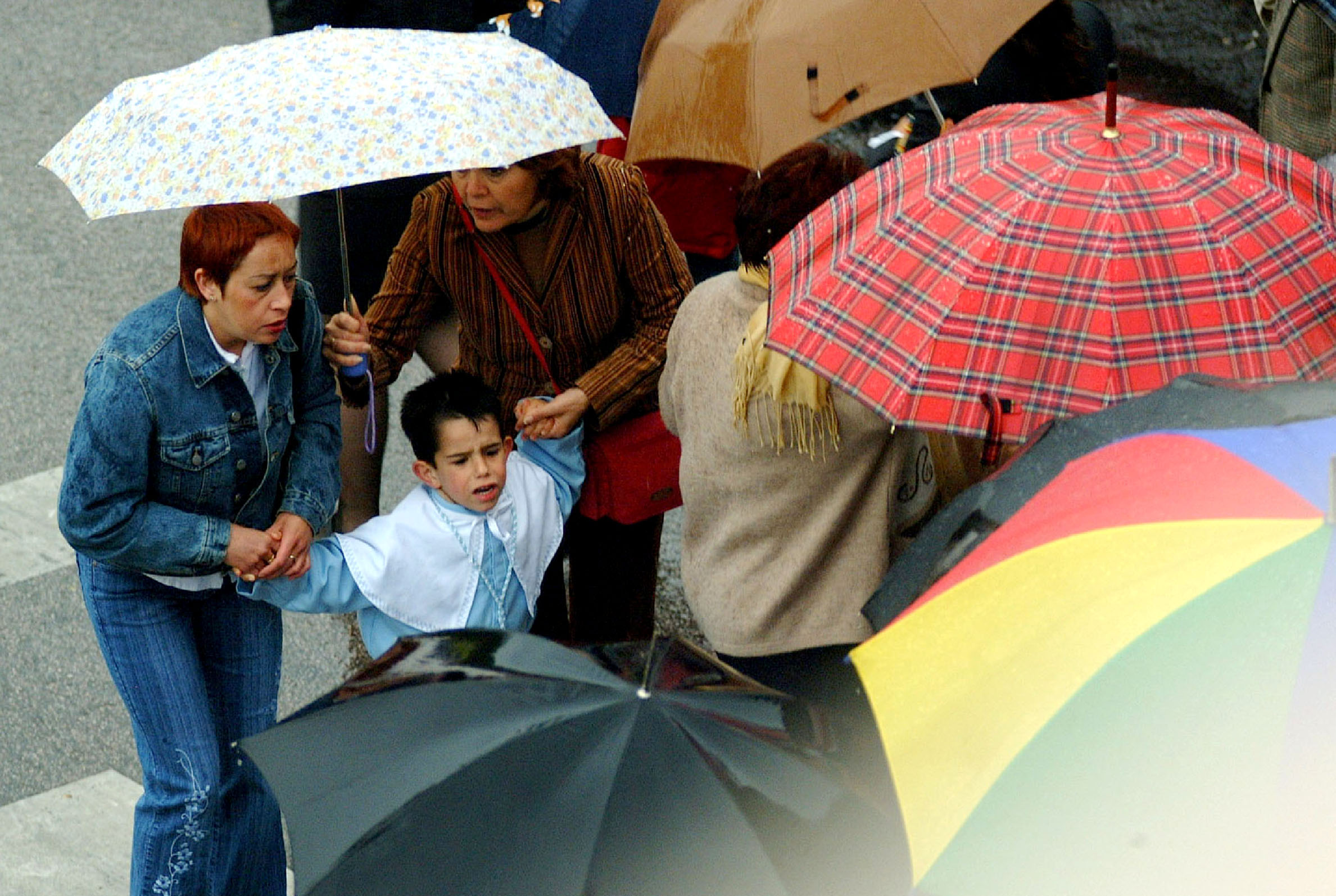 Un niño llora porque la lluvia ha frustrado su ilusión de participar en la procesión de la Virgen de la Montaña. 