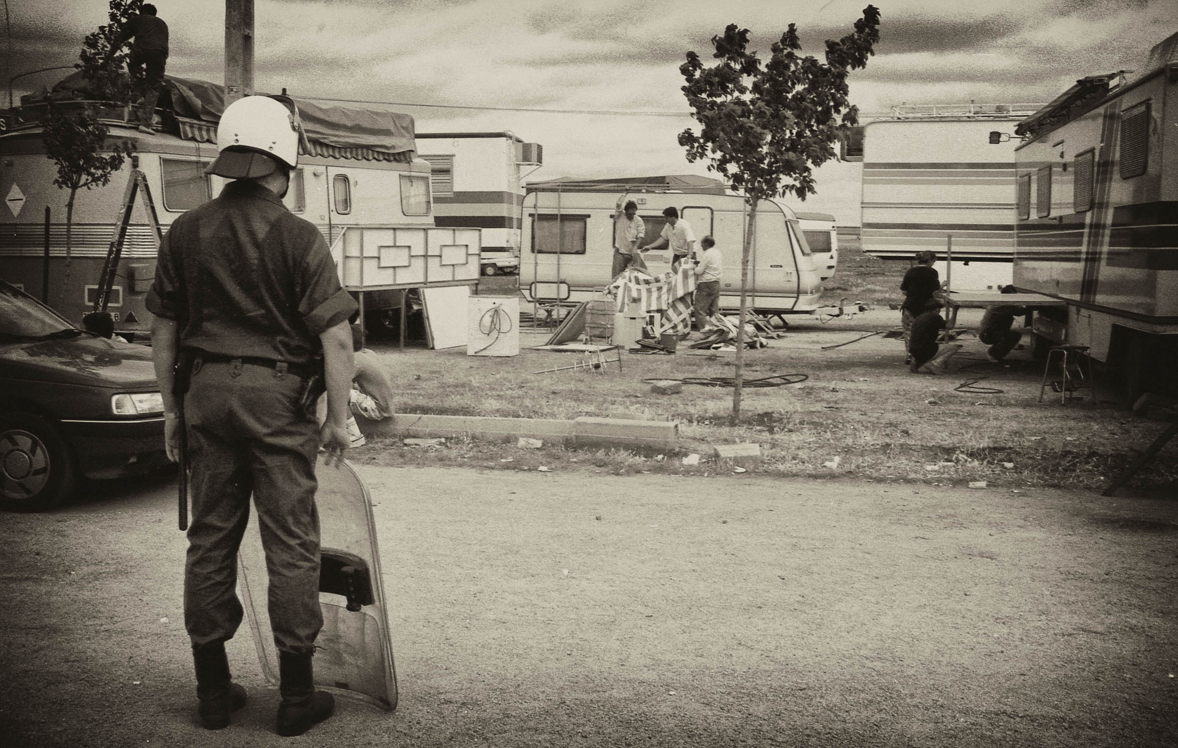 Un agente antidisturbio ante las caravanas de los feriantes en el ferial de Cáceres (22 de mayo de 1992). Un agente antidisturbio ante las caravanas de los feriantes en el ferial de Cáceres (22 de mayo de 1992).