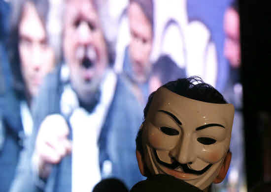 DOCU_GRUPO Activist looks at Five Star Movement leader and comedian Grillo on the screen during a rally in Rome Un simpatizante de Anonymus escucha la intervención de Beppe Grillo a través de una pantalla. Reuters