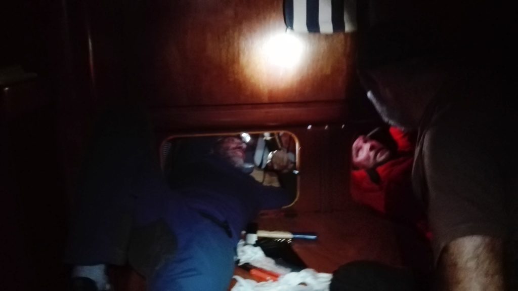 Con Manu, luchando por arreglar la avería. Elena nos va pasando las herramientas y arriba en la cubierta está Juanjo agarrado a la palanca de fortuna sujetando el timón, para poder bloquearlo y no nos aplaste las manos en el reducido espacio que tenemos para poder reparar la avería. Foto de Elena