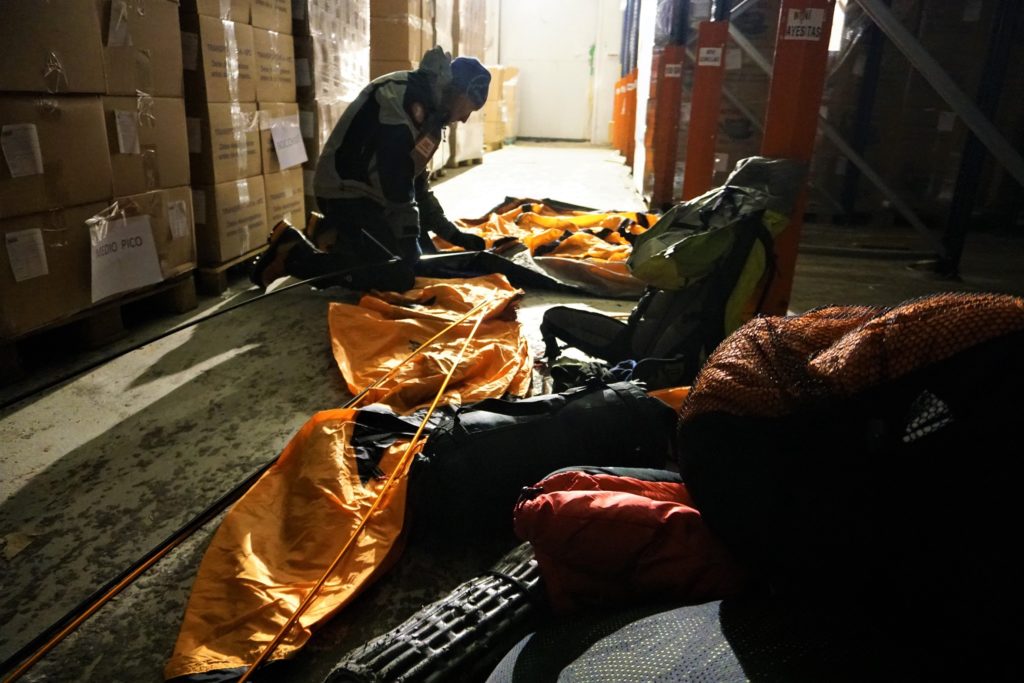 Manipulando con unos guantes finos una tienda de campaña dentro de la una cámara frigorífica a -18ºC.